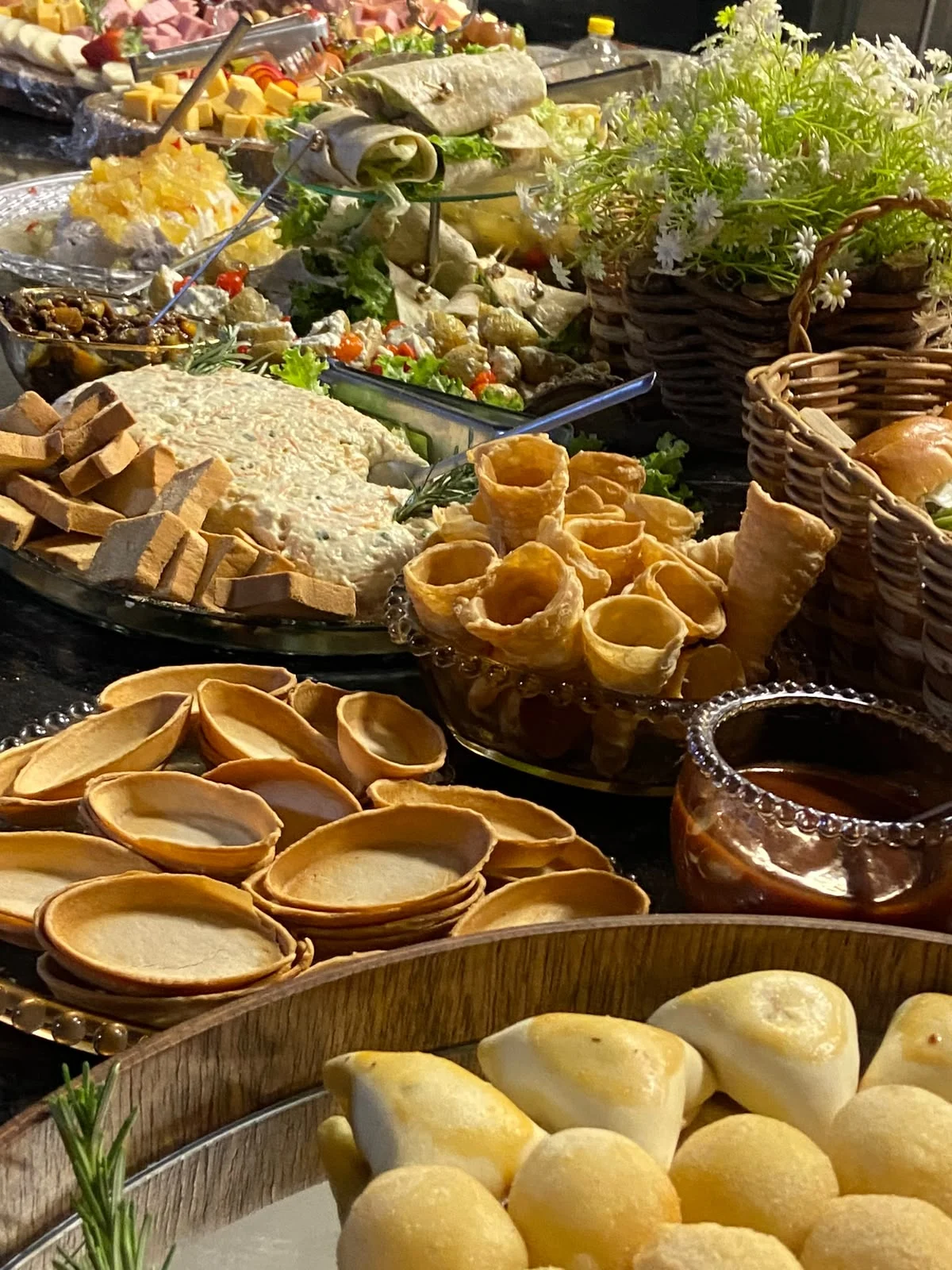 Detalhes de uma mesa com frutas, pães e acompanhamentos